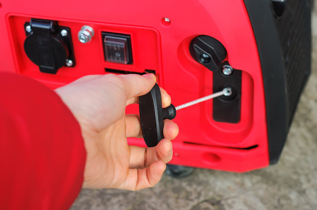 Close-up of a hand starting a generator.