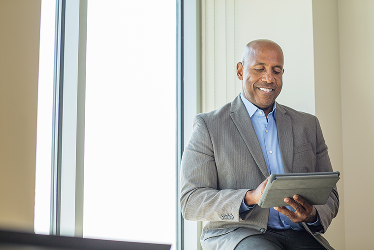 Businessman browsing on tablet computer.